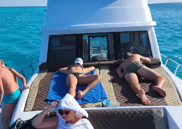 Comfortable sunbeds on the deck of a private boat for sunbathing.