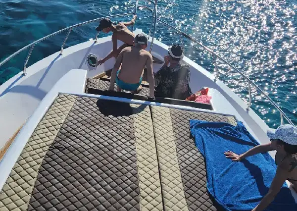 A group of friends relaxing and sunbathing on the boat deck
