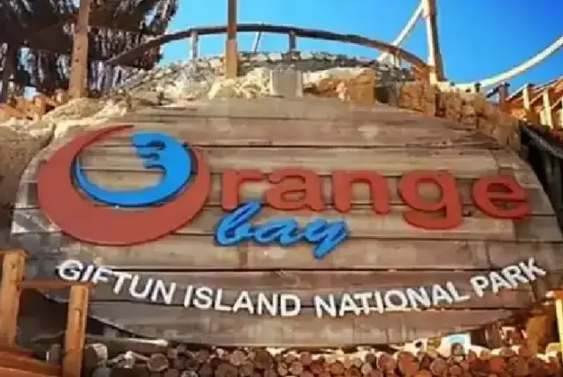 The famous wooden sign of Orange Bay at Giftun Island National Park, a top destination for Hurghada Red Sea excursions.
