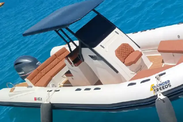 Side view of a white luxury speedboat cruising through the Red Sea waves.