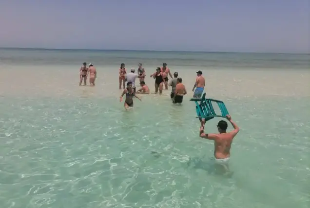 Friends gathering on the sandy shallow waters of Abu Minqar Island in Hurghada Red Sea.